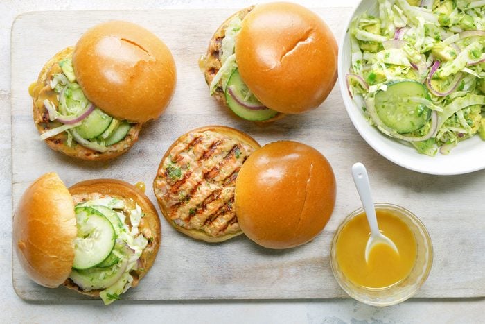 Close shot of Salmon Burgers with Tangy Slaw; wooden board; marble background;